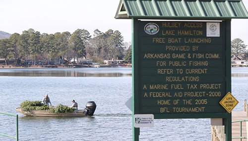 Boat loaded with trees leaving Hulsey Access on Lake Hamilton