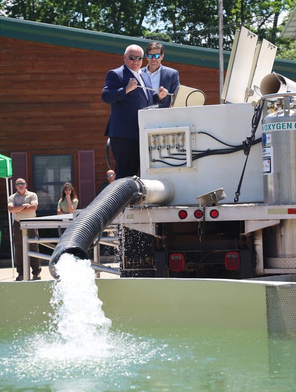 Commission Chairman Bobby Martin and Director Austin Booth releasing trout