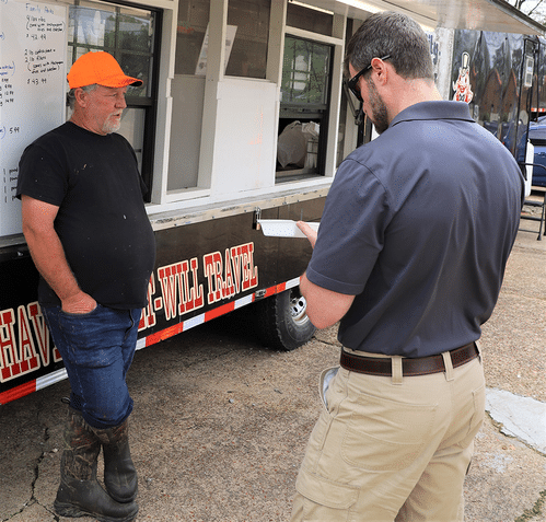 Two men talking David Thomas (left) discusses his process for turning invasive carp into healthy meals with Matt Horton, AGFC aquatic nuisance species coordinator.