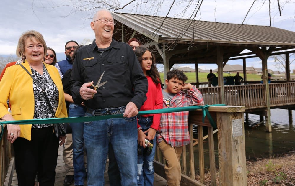 Debbie and Bill Jarboe, with family members behind them, cut the ribbon to dedicate the Bill Jarboe Family Fishing Pavilion.