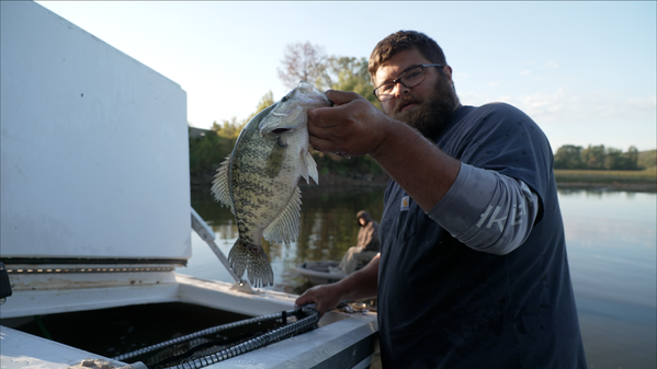 Man with Fish: AGFC Habitat Coordinator Will Lancett loads a ‘slabomoondo’ crappie into the nursery pond for anglers.