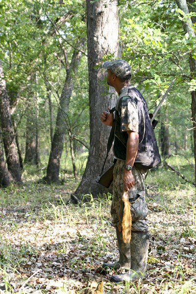 spring squirrel hunter carrying squirrel