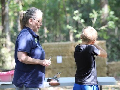 AGFC employee helping a child shoot BB guns