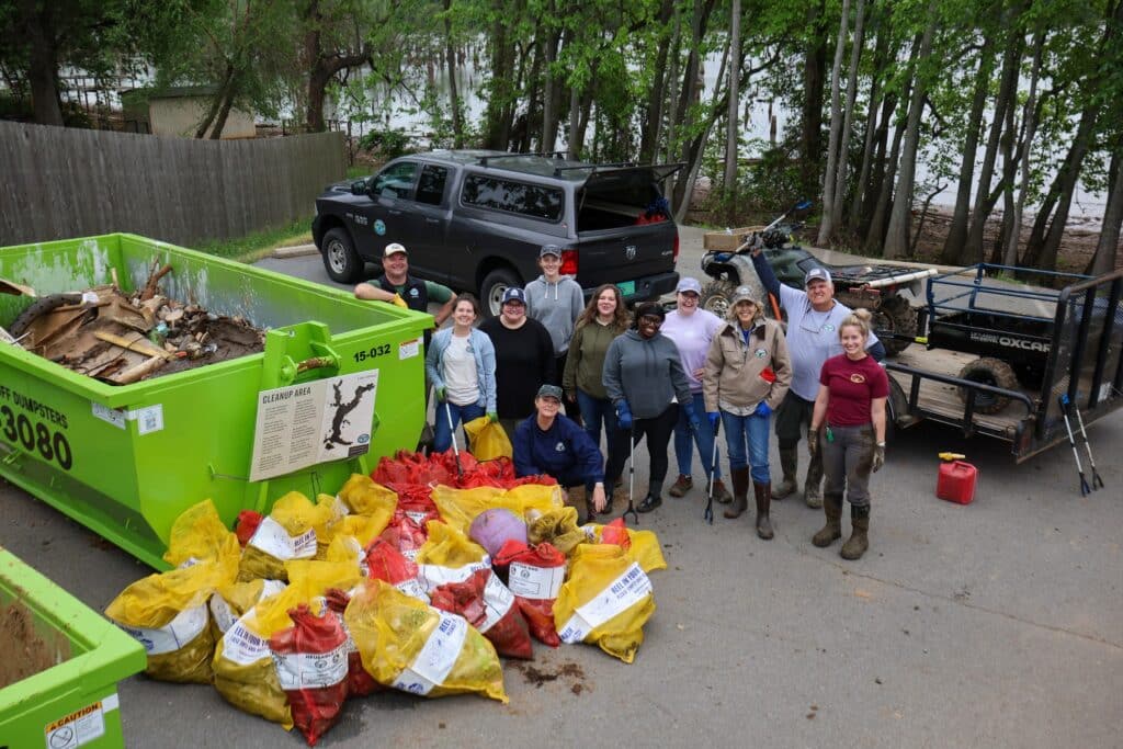 AGFC employees standing next to the trash they collected at Lake Conway.