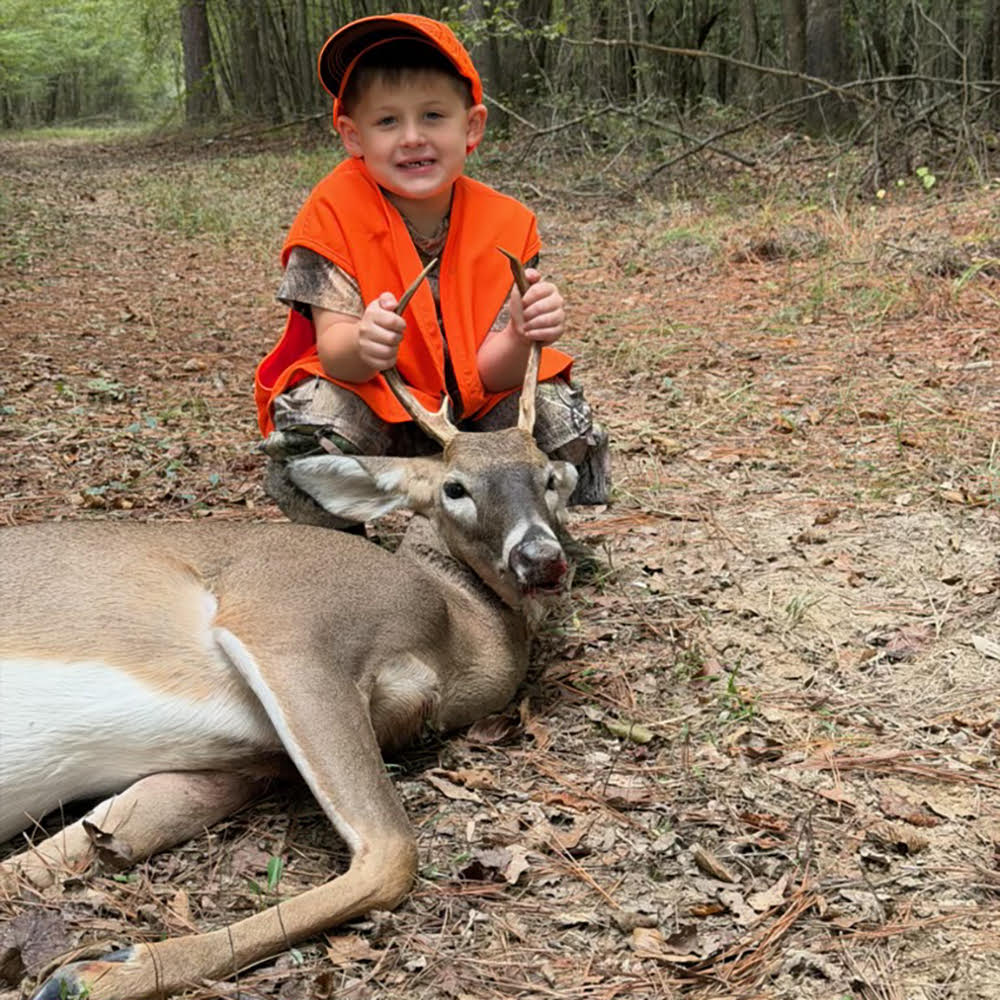 YOUTH IN ORANGE WITH DEER